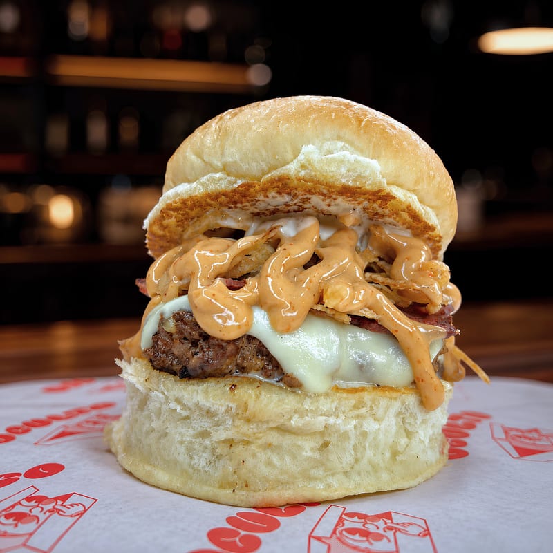 Hamburguesa Infiltrada Burger Smash con cebolla asada y queso cheddar